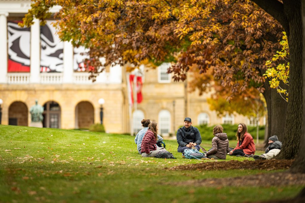 A group of masters students in the Nelson Institute Environmental Conservation program have an informal meeting outside on a warm day among the colors of the fall leaves on Bascom Hill at the University of Wisconsin-Madison during autumn on November 10, 2021. (Photo by Bryce Richter / UW-Madison)